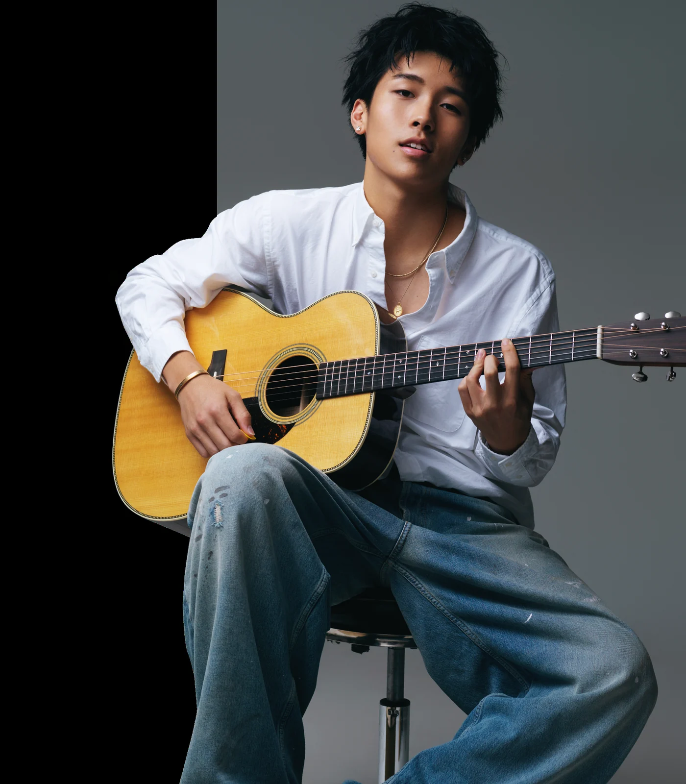 Tony D seated with an acoustic guitar